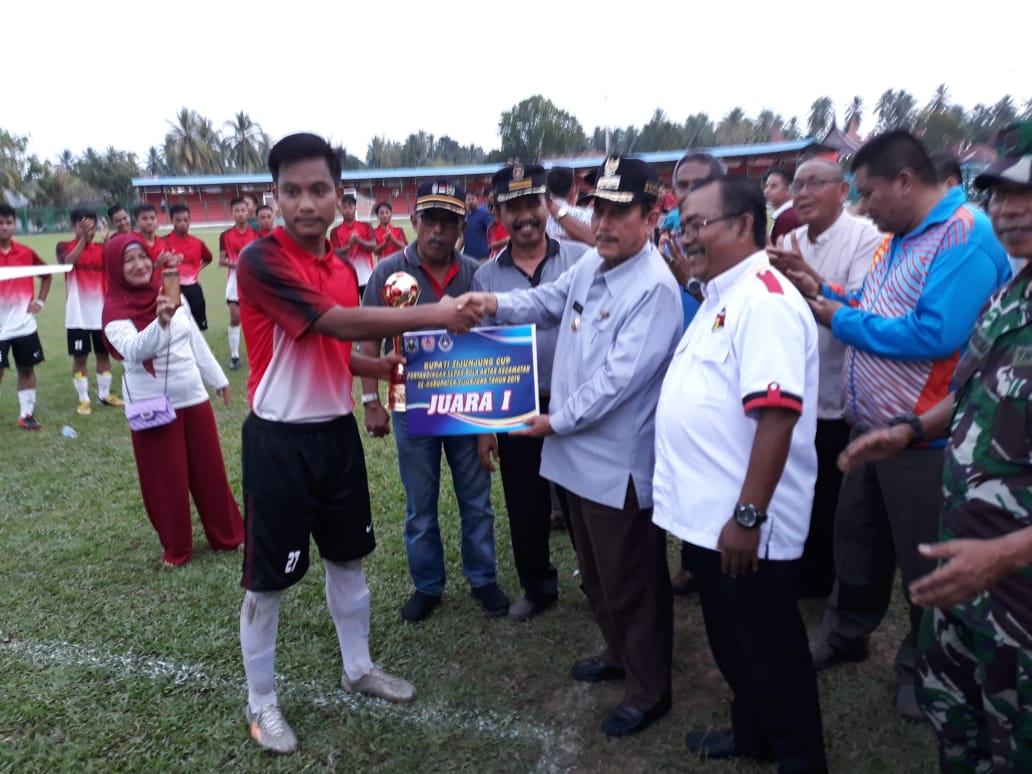 Bupati Yuswir Arifin didampingi Panitia Minangkabau Cup Nofi Sastera menyerahkan piala kepada kapen tim Kamang Baru